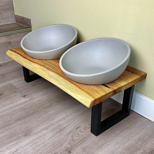 Design Futterstation für Hunde mit natürlicher Eichenholzbohle und geradlinigen Fußgestellen mit natürlich herausgearbeiteter Baumkante und Betonoptik Näpfen aus Melamin